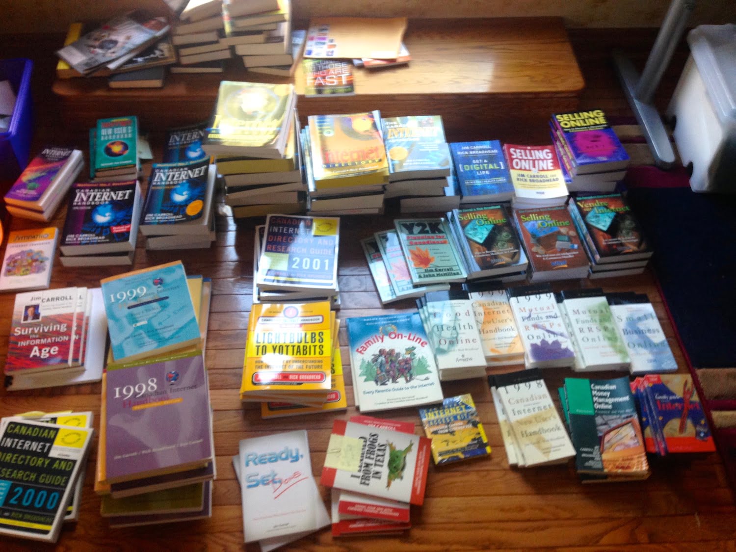 Family photograph showing Jim Carroll's wide collection of Internet, business, finance, and innovation books arranged in stacks across the floor